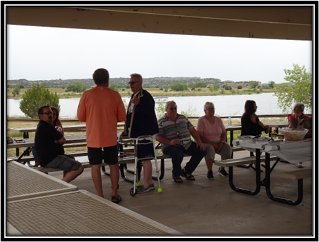 A group of people sitting under a shelter

Description automatically generated