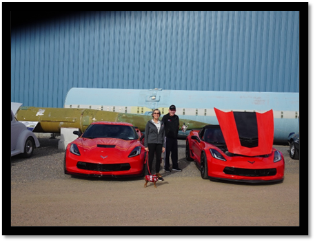 A couple of people standing next to a couple of red sports cars

AI-generated content may be incorrect.