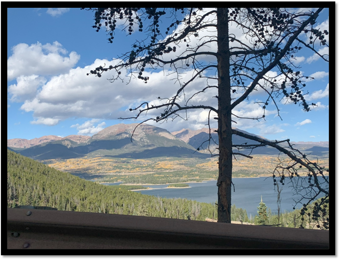 A view of a lake and mountains from a road

Description automatically generated