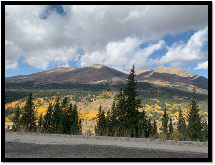 A mountain range with trees and clouds

Description automatically generated