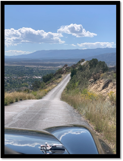 A road with trees and mountains in the background

Description automatically generated