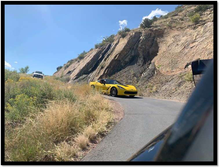 A yellow car on a road

Description automatically generated