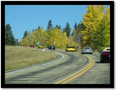 A group of cars driving on a road

Description automatically generated