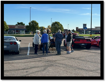 A group of people standing around a red sports car

AI-generated content may be incorrect.