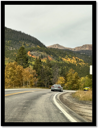 A car driving on a road with trees and mountains in the background

AI-generated content may be incorrect.