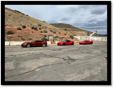 A group of red sports cars parked on a road

AI-generated content may be incorrect.