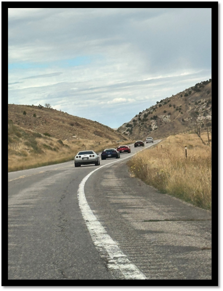 Cars on a road with hills in the background

AI-generated content may be incorrect.