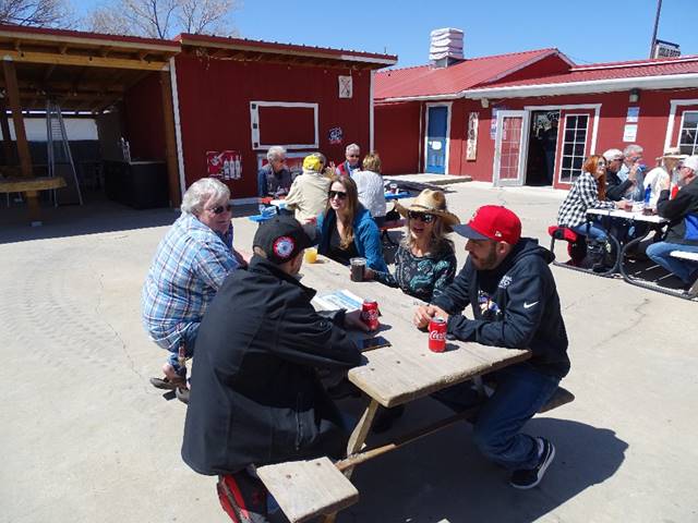 A group of people sitting around a table outside

Description automatically generated with medium confidence