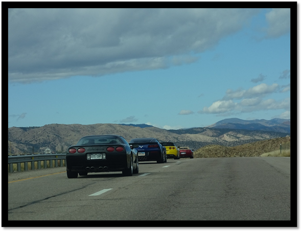 A group of cars parked on a road with mountains in the background

Description automatically generated with medium confidence