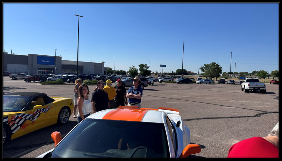 A group of people standing in a parking lot

Description automatically generated