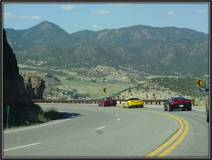 A group of cars driving on a road

Description automatically generated