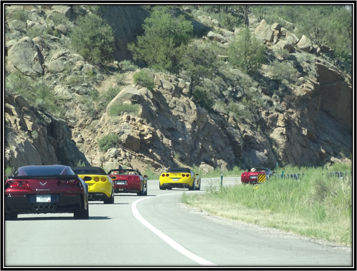 A group of cars driving on a road

Description automatically generated