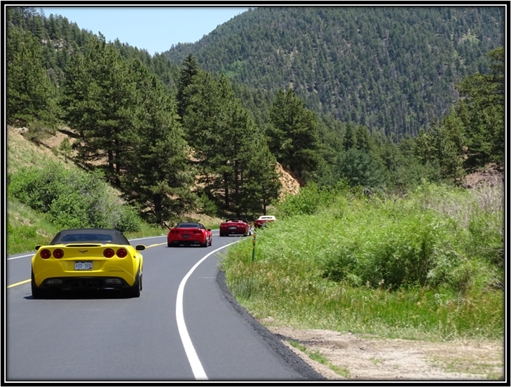 A group of cars driving on a road

Description automatically generated