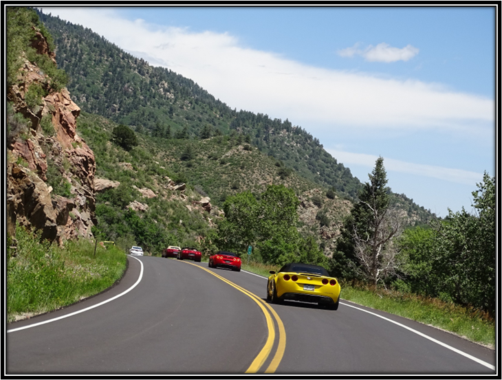 A group of cars driving on a road

Description automatically generated