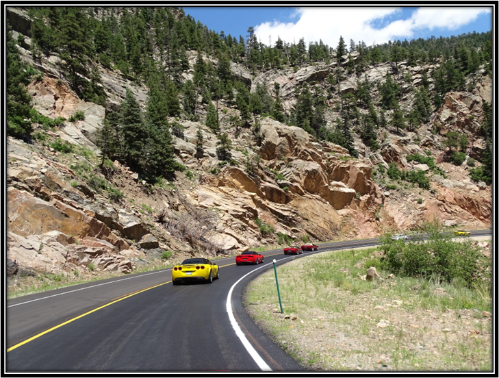 A group of cars driving on a road

Description automatically generated