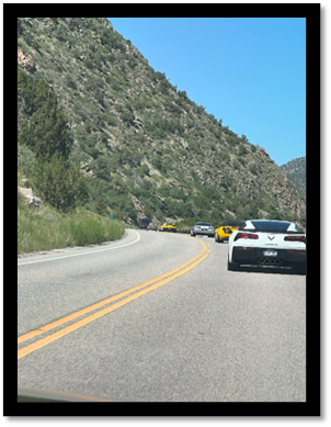 Cars on the road with a hill in the background

AI-generated content may be incorrect.