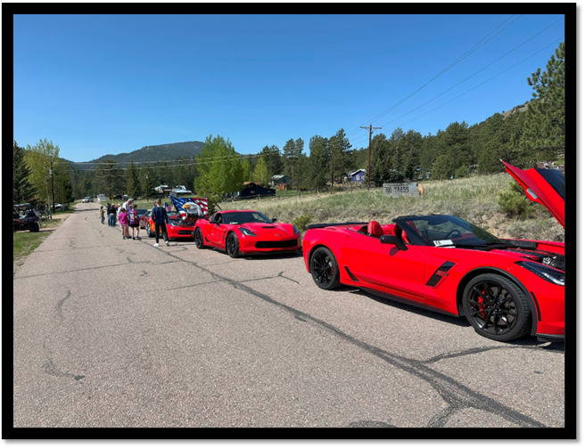 A group of people standing in a line of red sports cars

AI-generated content may be incorrect.
