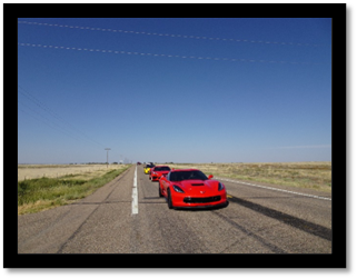 A group of red cars on a road

Description automatically generated