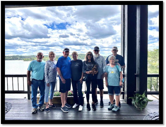 A group of people standing on a deck

Description automatically generated