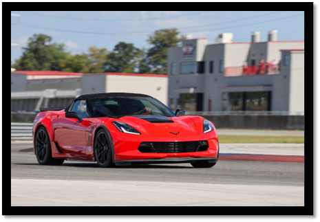 A red sports car on a race track

Description automatically generated