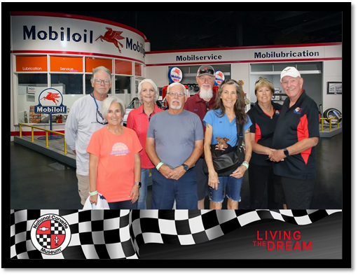 A group of people standing in front of a gas station

Description automatically generated