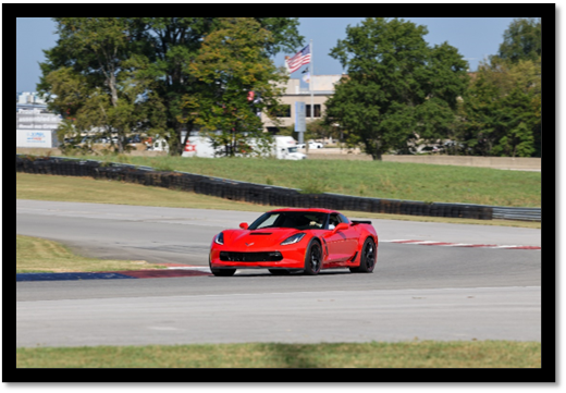 A red sports car on a race track

Description automatically generated