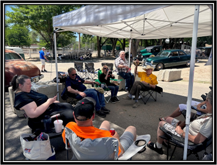 A group of people sitting under a white tent

Description automatically generated