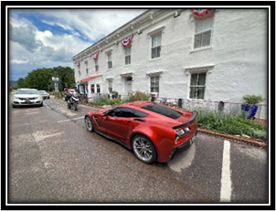 A red sports car parked in front of a building

Description automatically generated