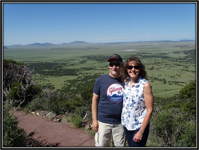 A person and person standing on a hill

Description automatically generated