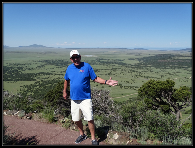 A person standing on a hill with his arms out

Description automatically generated