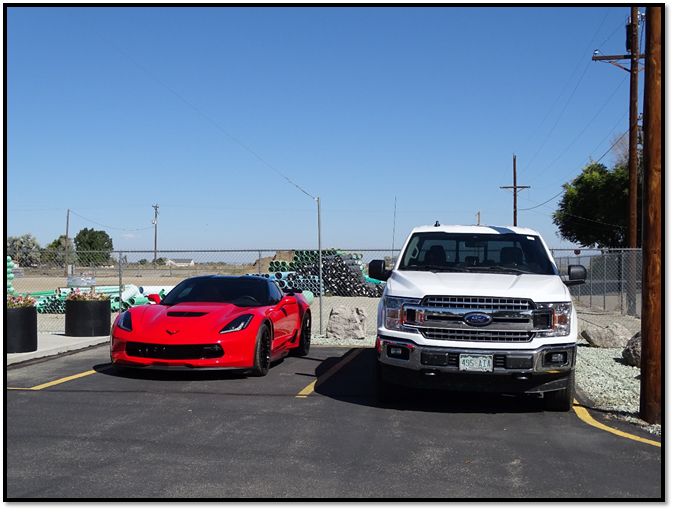 A red car and a white car parked on the side of a road

Description automatically generated with medium confidence