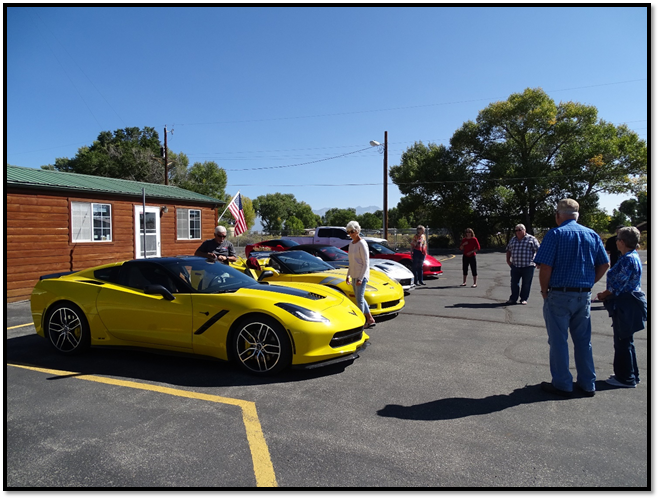 A yellow sports car parked in a parking lot with people standing around

Description automatically generated with medium confidence