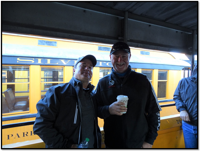 Two men standing in front of a train

Description automatically generated with low confidence