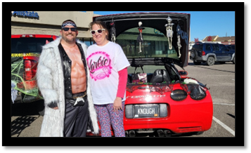 A person and person standing next to a car

Description automatically generated