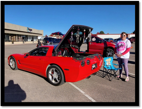 A red car with its trunk open

Description automatically generated