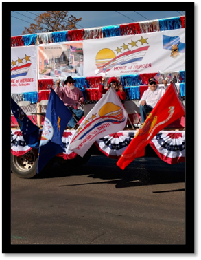 A group of people sitting on a truck with flags

AI-generated content may be incorrect.