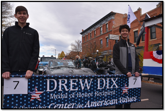 A couple of men holding a sign

Description automatically generated with low confidence