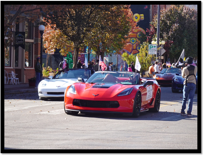 A group of cars driving on a street

Description automatically generated