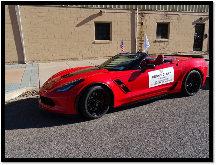 A red sports car parked in front of a building

Description automatically generated