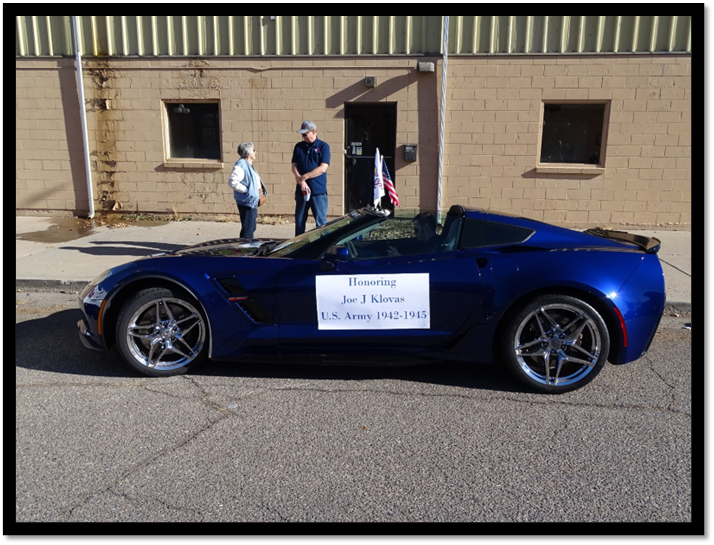 A blue sports car with a sign on the side

Description automatically generated