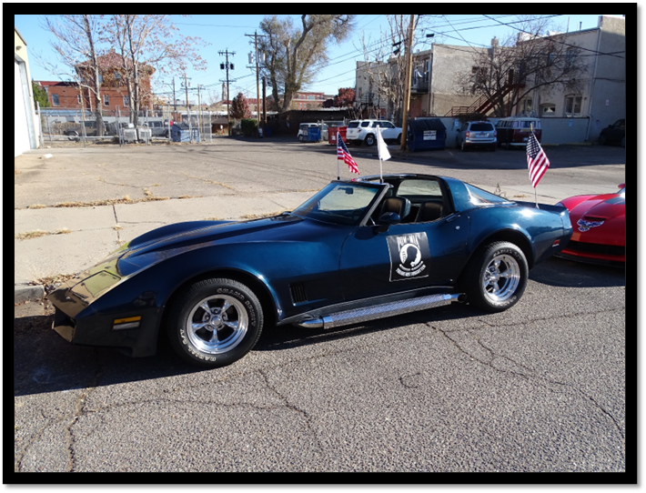 A blue sports car parked on the side of a road

Description automatically generated