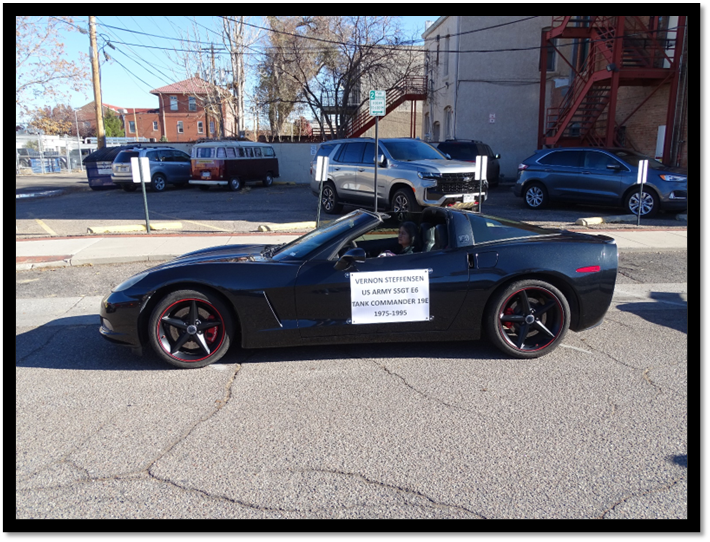 A black sports car with a sign on the side of it

Description automatically generated