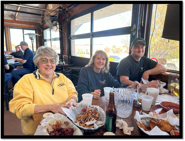 A group of people sitting at a table with food

Description automatically generated