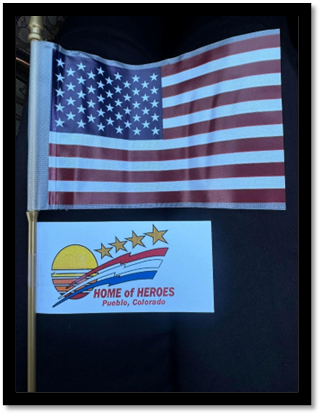 A flag next to a sign

Description automatically generated