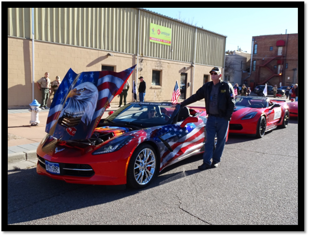 A person standing next to a red car with a flag painted on it

Description automatically generated