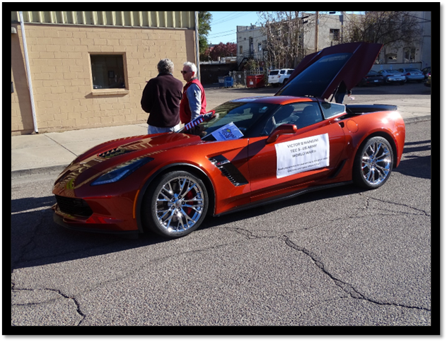 A red sports car with its hood up

Description automatically generated