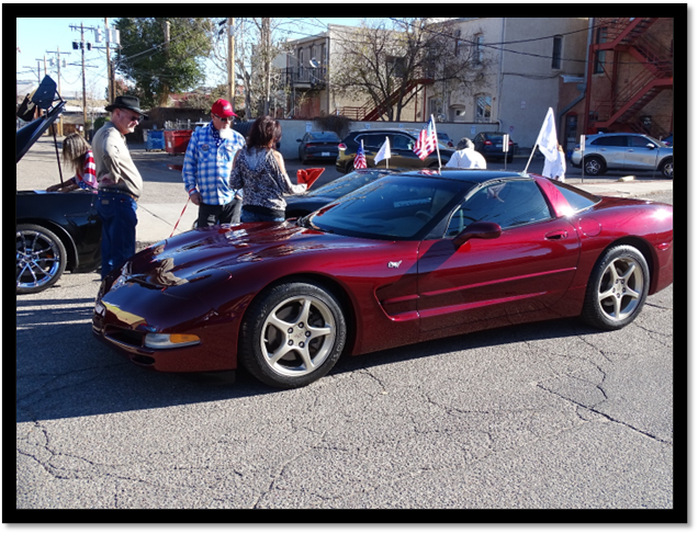A red sports car parked on the street

Description automatically generated