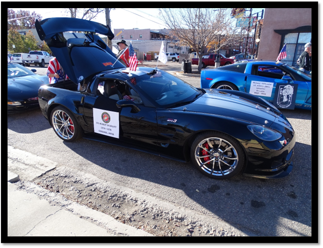 A black sports car with its hood up

Description automatically generated