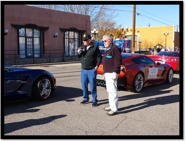 A group of men standing next to a car

Description automatically generated