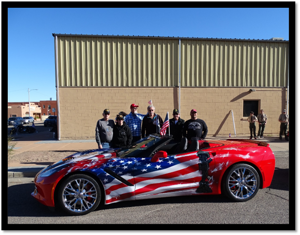 A group of people standing next to a red white and blue car

Description automatically generated